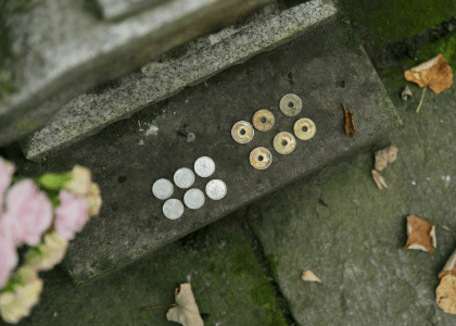 長谷寺裏にある真田幸隆・昌幸の墓前に供えられた賽銭。真田氏の家紋「六文銭」を模している。